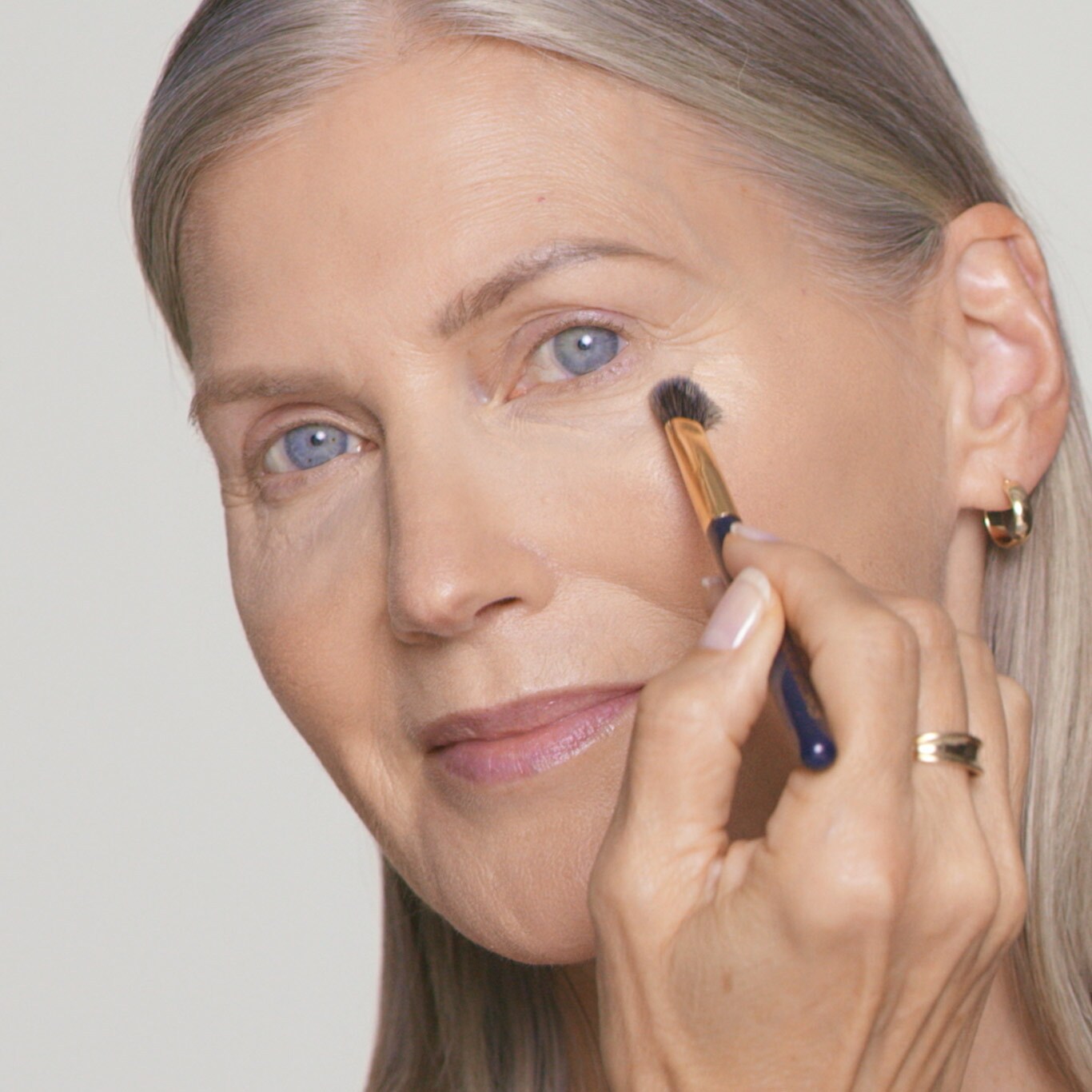 Le modèle applique un gel-crème sous les yeux